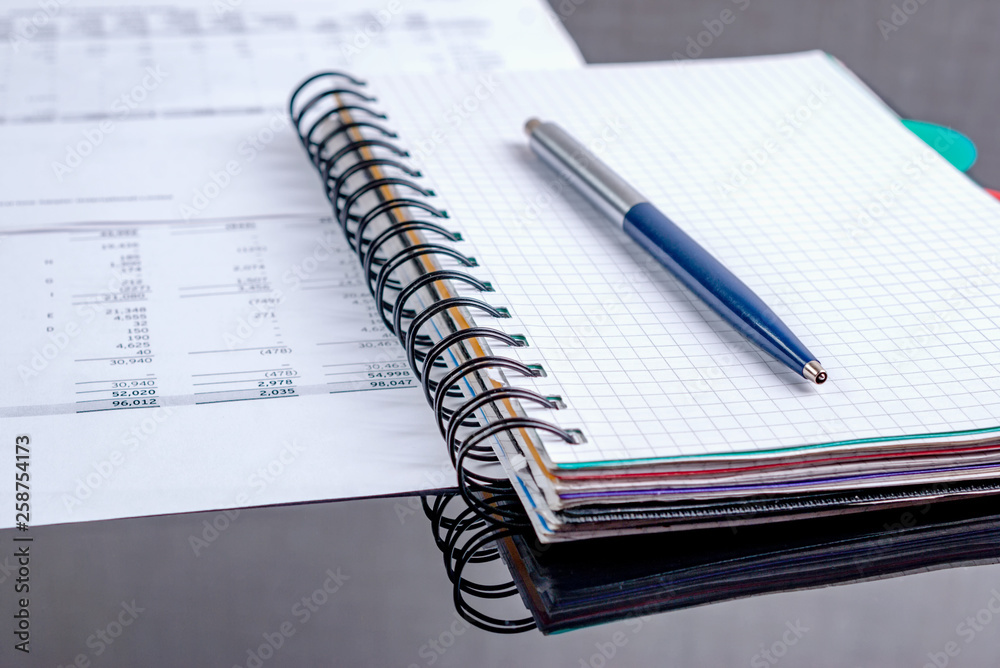 Business concept - notebook, business papers on a black table. Business concept - notebook, business papers on a black table.