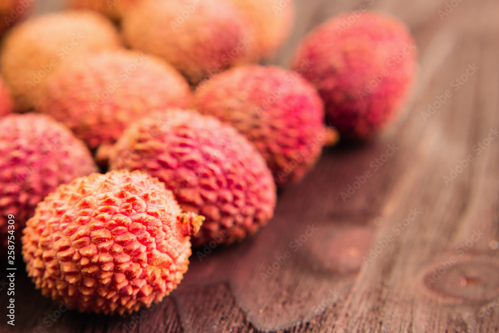 Fresh organic lychee fruit on brown wooden background. Fresh organic lychee fruit on brown wooden background.