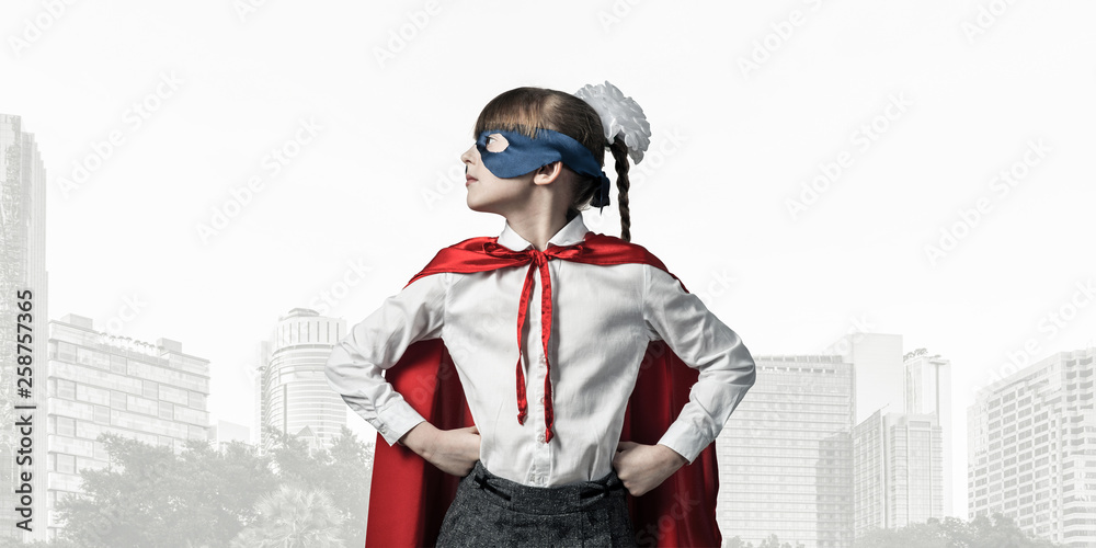 Obraz premium Girl power concept with cute kid guardian against cityscape background