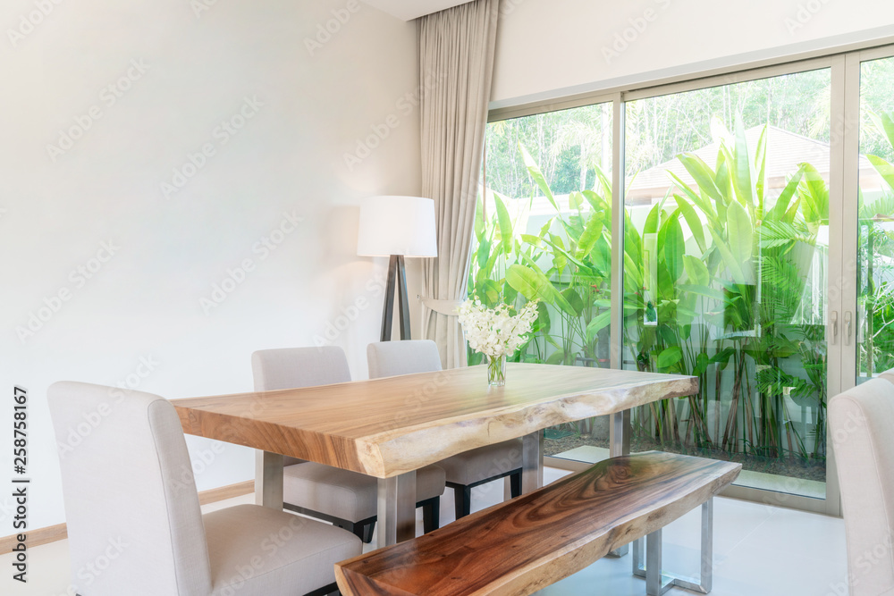 Fototapeta premium Luxury interior design in living room of pool villas. Airy and bright space with high raised ceiling and kitchen area with dining table