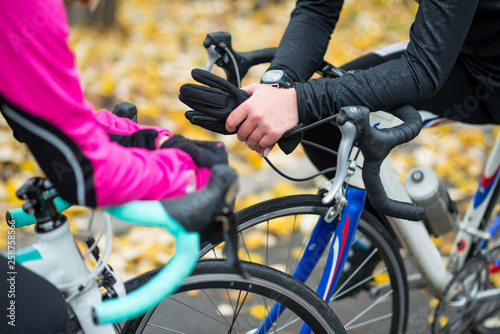 Two Young Female Cyclists with Road Bicycles Resting in the Park in Cold Autumn Day. Healthy Lifestyle.