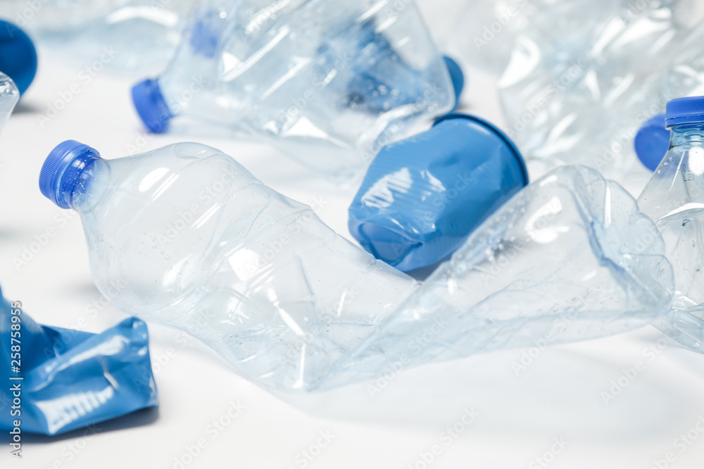 Fototapeta premium Crumpled empty single-use plastic cups and bottles, studio shot. Plastic pollution concept. Single-use plastic is a human addiction that is destroying our planet 