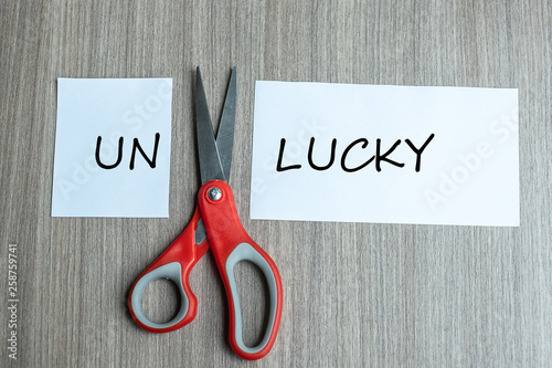 Принти на полотні red scissors and cutting white paper with the text Unlucky, change word to Lucky
