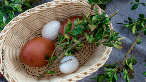 Koszyczek wiklinowy z jajkami i gałązkami bukszpanu. Wielkanocna tradycja w Polsce. 