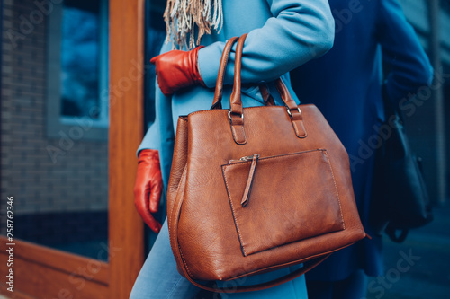 Beauty and fashion. Stylish fashionable woman wearing coat and gloves ,holding brown bag handbag photo
