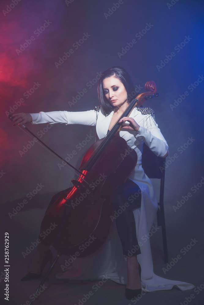 Beautiful woman in a white coat plays the cello Beautiful woman in a white coat plays the cello