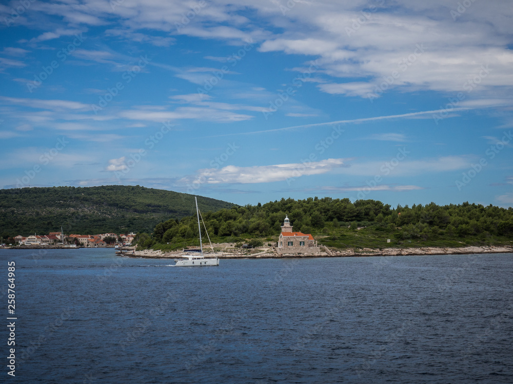 Ferry passing close to Sucuraj lighthouse on Hvar island, Croatia