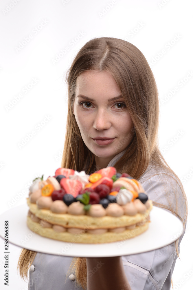baker girl with a cake with berries on a white background baker girl with a cake with berries on a white background