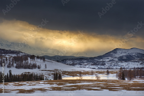 Gloomy spring sunset in the Altai mountains. Russia. The North-Chuyskiy ridge near the Kurai steppe.