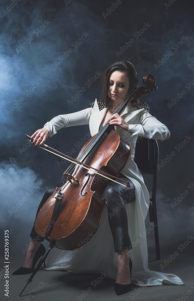 Beautiful woman in a white coat plays the cello Beautiful woman in a white coat plays the cello