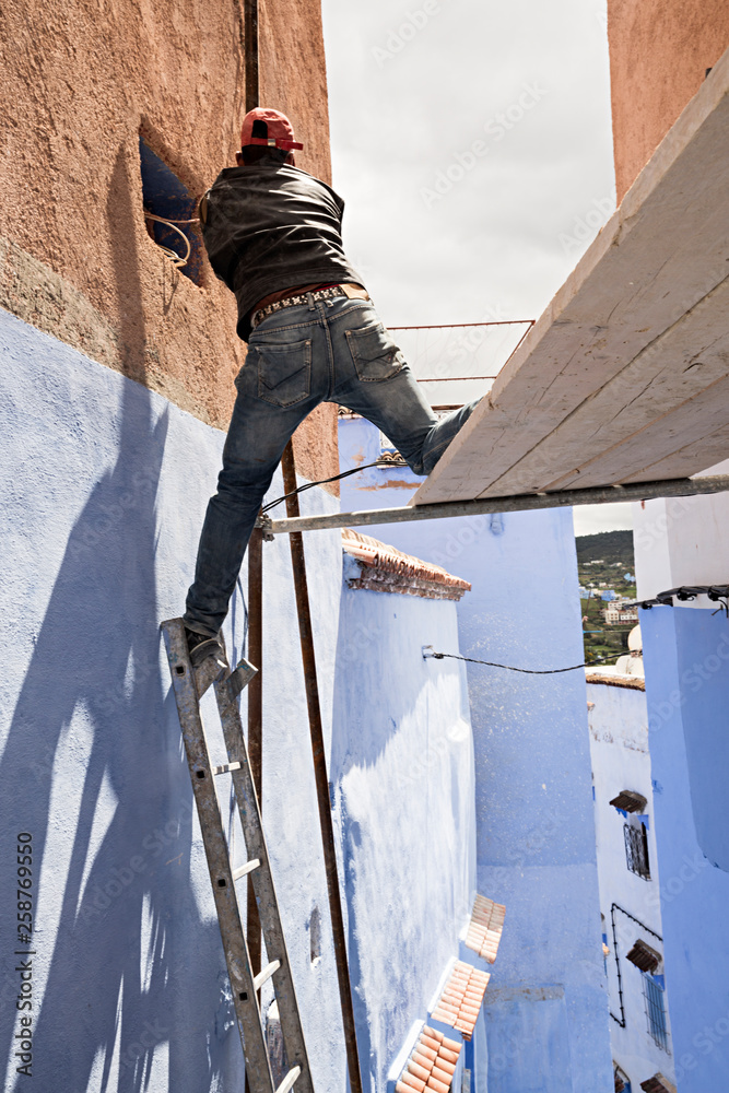 Obrero trabajando en un andamio sin seguridad. Stock Photo | Adobe Stock