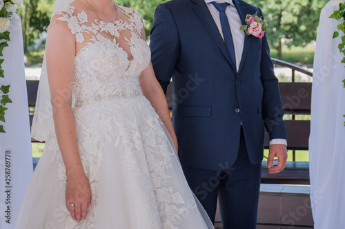 bride and groom stand together under the arch of the wedding ceremony