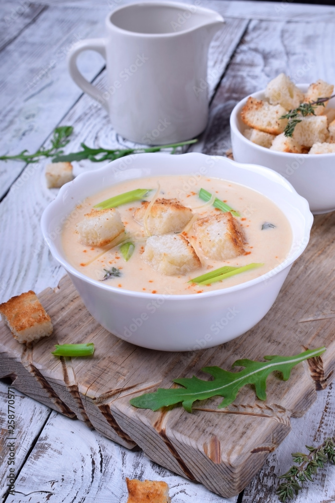 Cream soup with croutons, green onion and cheese in a white bowl Cream soup with croutons, green onion and cheese in a white bowl
