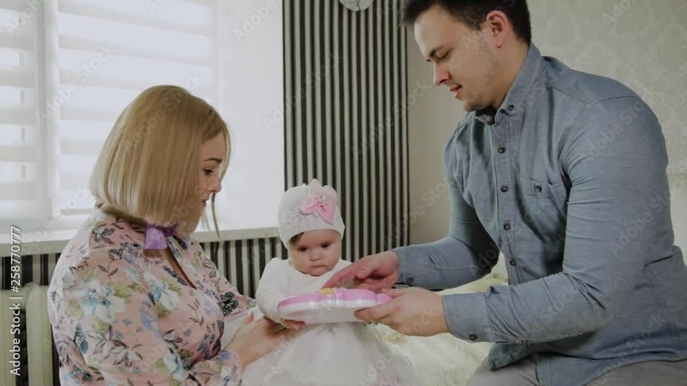 Happy family playing with their little daughter on a white bed. Happy family playing with their little daughter on a white bed.