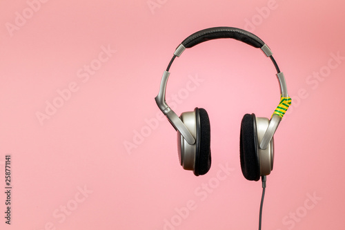 Headphones wrapped with duct tape on a pink background