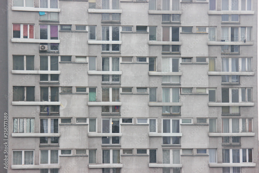 Windows of an apartment building, symmetrical frames in a gray house. many rooms in one house. modern housing construction.