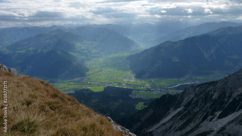 Fototapeta premium Isolated city caught in between the mountain chains before the sunset