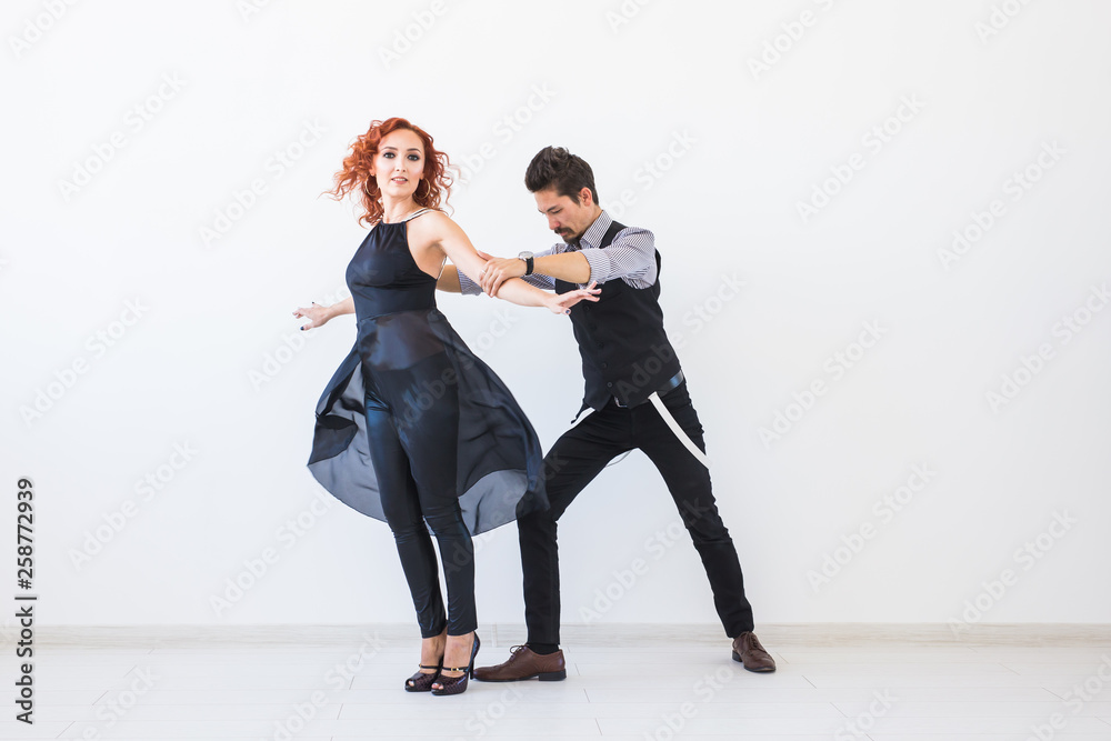 Fototapeta premium Social dance, kizomba, tango, salsa, people concept - beautiful couple dancing bachata on white background with copy space