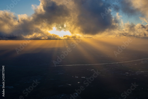 Beams of sun going through cloud onto evening land © Vladyslav Siaber