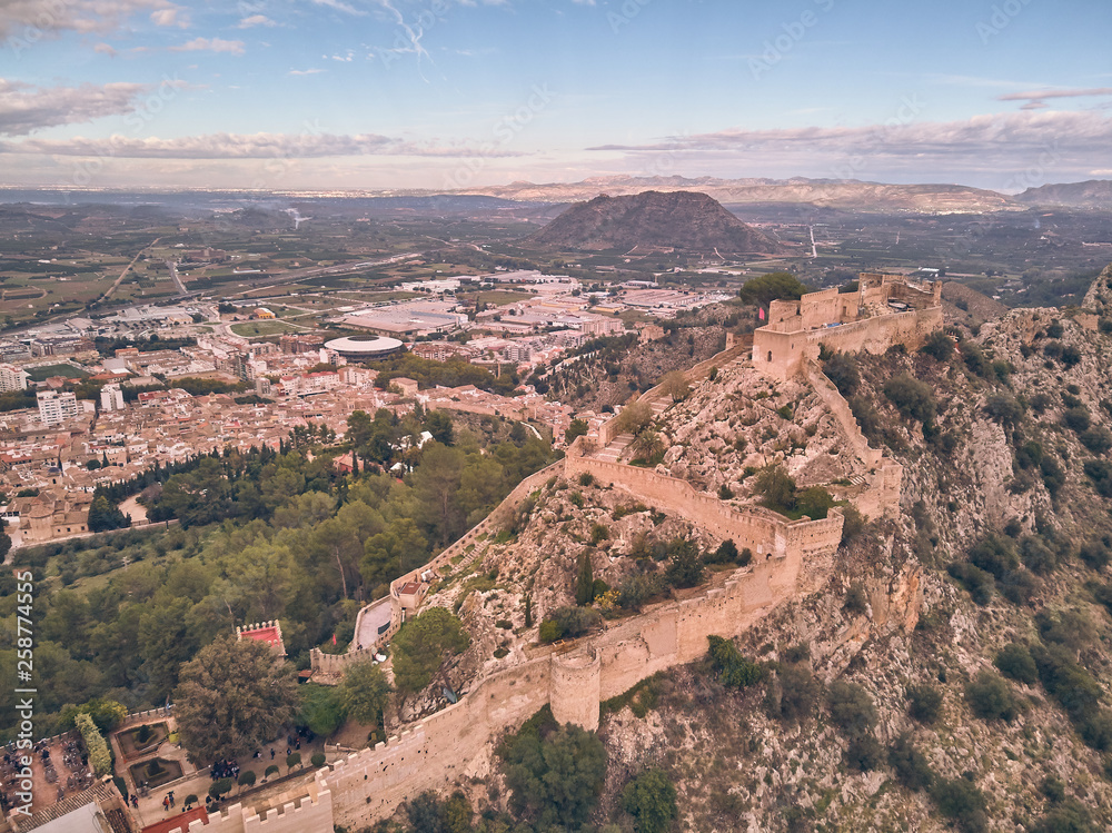Aerial view of the castle of Xativa with the town in the background on a day with blue sky and clouds