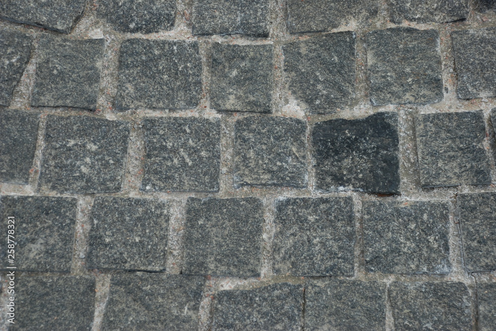 texture of the pavement laid out of granite stone. granite of gray and dark gray color, granite surface is rough