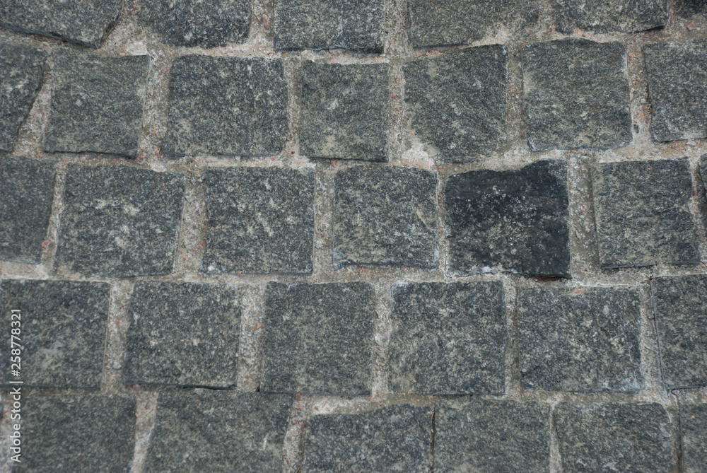 texture of the pavement laid out of granite stone. granite of gray and dark gray color, granite surface is rough texture of the pavement laid out of granite stone. granite of gray and dark gray color, granite surface is rough
