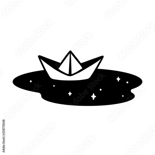 Paper boat in puddle