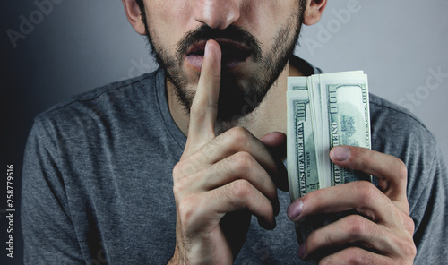 Bribery people with dollar bills in hand and quiet gesture