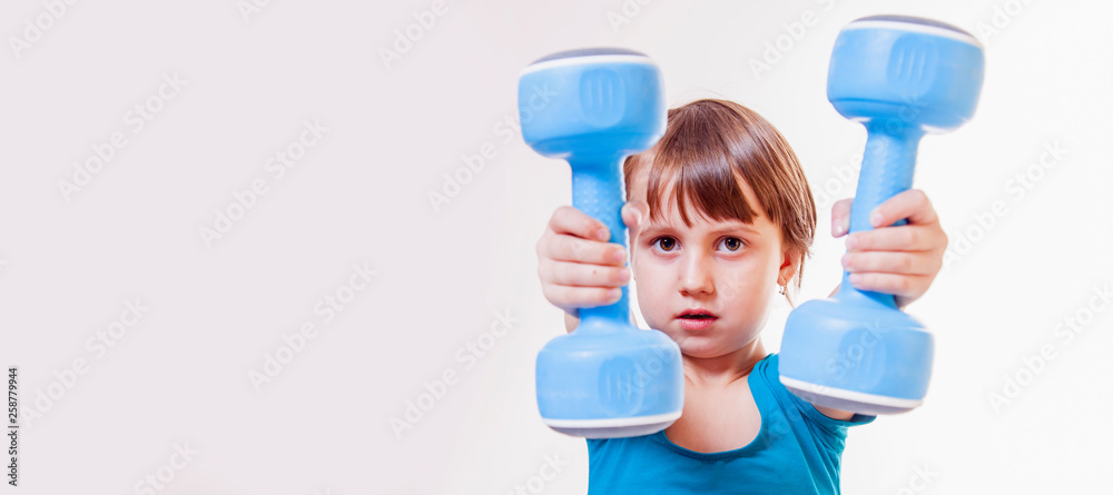 Dumbbell exercises for child. Portrait of strong child girl. Sport lifestyle, health, power, success concept. Dumbbell exercises for child. Portrait of strong child girl. Sport lifestyle, health, power, success concept.