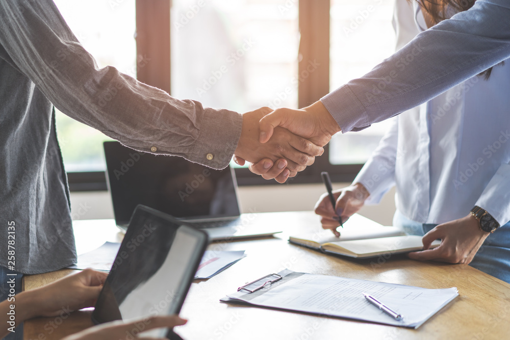 Two businessmen handshaking in meeting after final project agreement deal done.