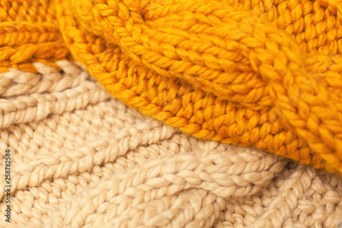 close-up, macro crocheted, wool products. warm, cozy blanket, sweater from a large woolen thread of beige and orange.