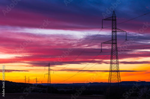 silhouetted high voltage tower at sundown