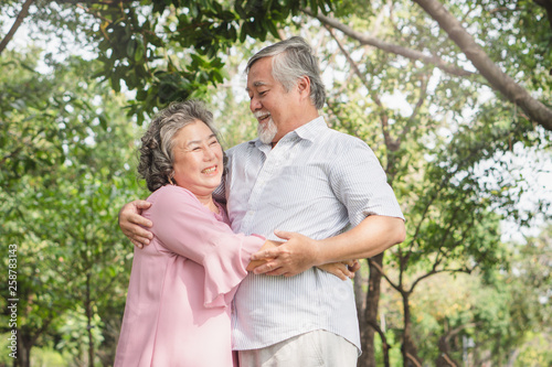 Happy elderly couple with lifestyle after retiree concept. Lovely asian seniors couple embracing together in the park in the morning. © Pormezz