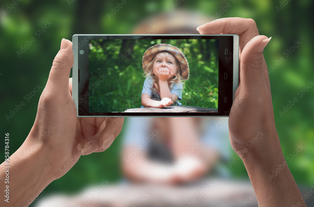 Cute little girl on smartphone screen
