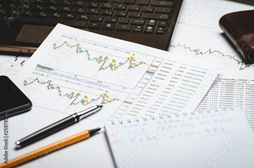 Financial charts of currencies on paper, profit analysis, financier's workplace