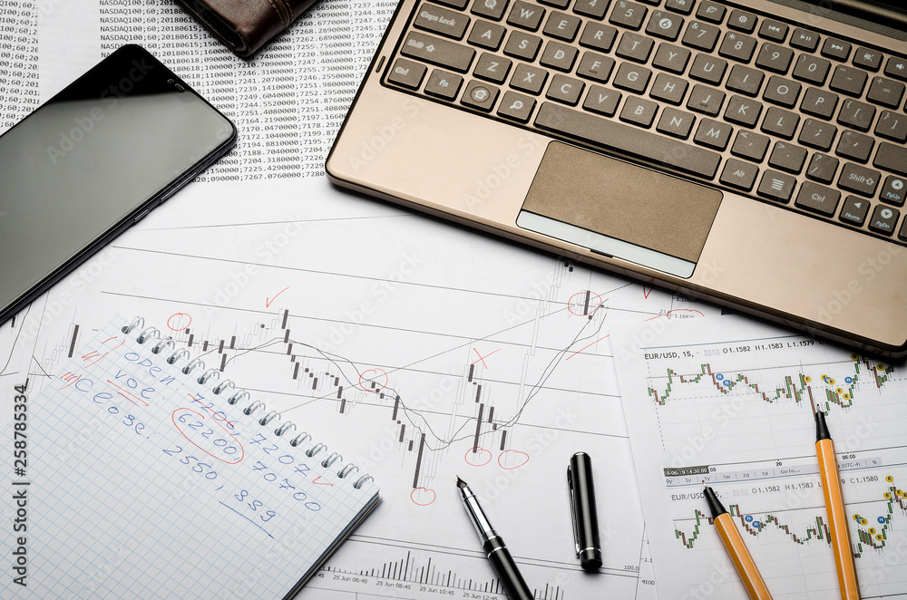 Financial charts of currencies on paper, profit analysis, financier's workplace