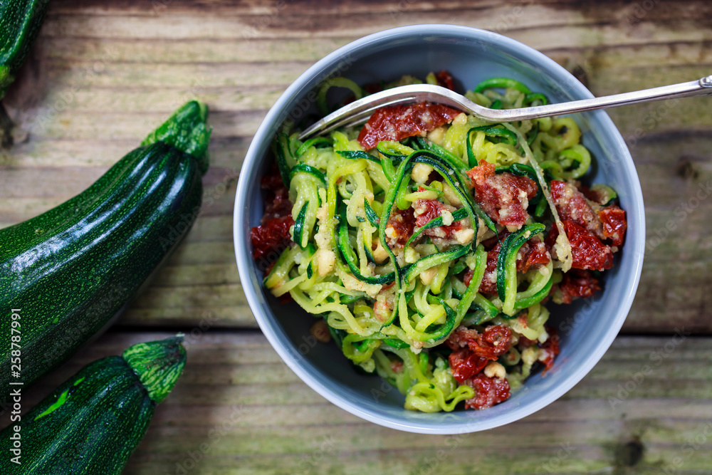 Courgette spaghetti with sun dried tomatoes and mince hazelnuts - obrazy, fototapety, plakaty 