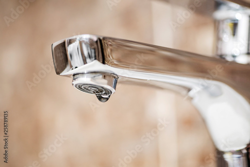 Faucet with dripping water. Tap closeup with dripping water-drop. Water leaking, saving concept