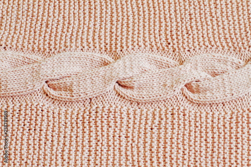 Fragment of original gentle pink knitted background with longitudinal knitted oblique. Handmade.