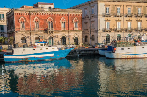 A colorful variety of boats and ships fill the docks of the harbors of the island of Ortygia, Syracuse (Siracusa), a historic city on the island of Sicily, Italy.
