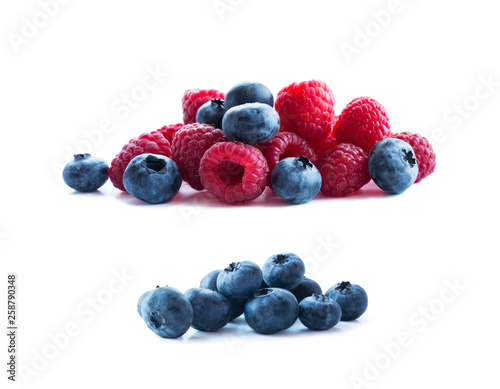 Ripe blueberries and raspberries. Background of mix berries with copy space for text. Mix berries isolated on white background. Pink and blue food on white background.