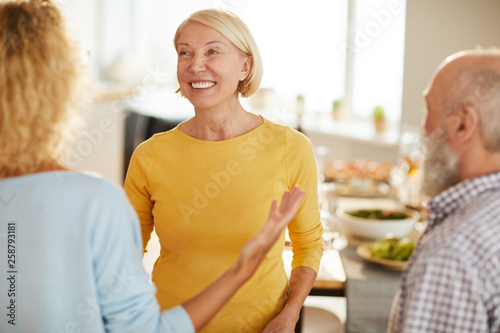 Принти на полотні Positive excited attractive mature lady with short blond hair listening to frien