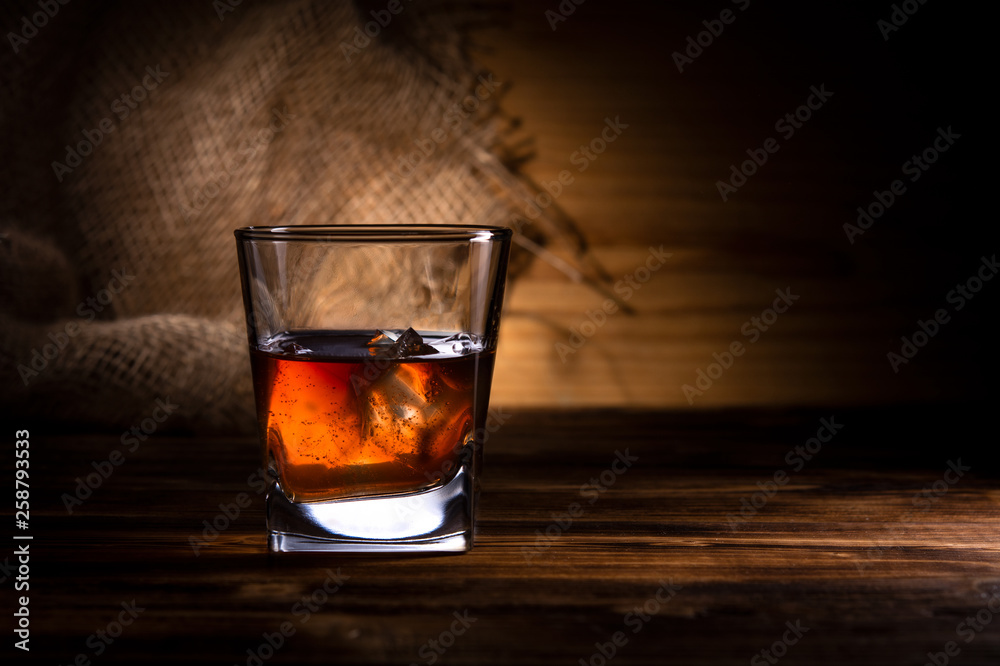 glass of whiskey or cognac on a wooden background glass of whiskey or cognac on a wooden background