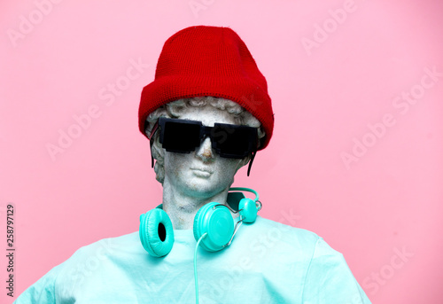Fotografie Antique bust of male in hat with headphones and sunglasses