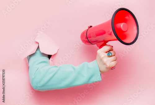 Female hand in classic blue jacket with megaphone photo