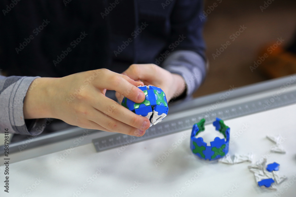 The child collects the plastic parts of the children's model kit The child collects the plastic parts of the children's model kit