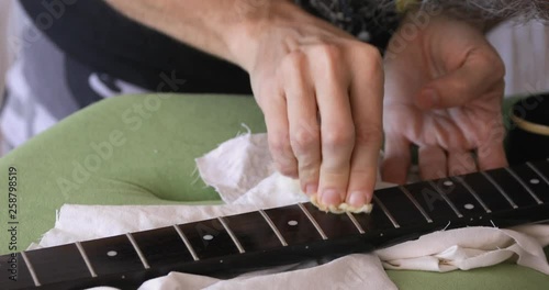 DIY, guitar maintenance, oiling rosewood fretboard at  vintage  style semihollow body electric guitar photo