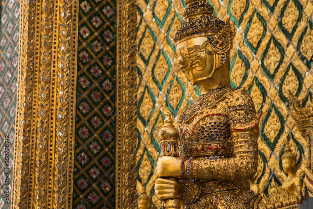 Golden guardian demon statue protecting  Bangkok Grand Palace in Thailand