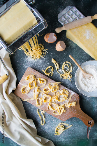 Still life homemade pasta. Pasta maker, eggshells, flour on a dark table. top view