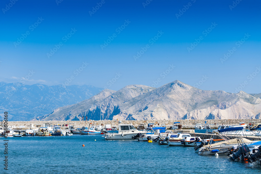 Wonderful romantic summer afternoon landscape panorama coastline Adriatic sea. Boats and yachts in harbor at cristal clear turquoise water. Baska on the island of Krk. Croatia. Europe.